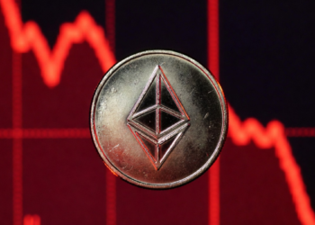 Moneda de Ethereum y gráfico de precio en caída rojo.