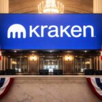 Imagen del logo del exchange Kraken en un sistema bancario con la bandera de EE. UU.