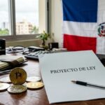Moneda física de bitcoin y otras criptomonedas, en un escritorio con un papel que dice "Proyecto de ley", y de fondo la bandera de República Dominicana.