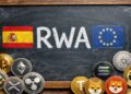 Una pizarra que tiene escrito la palabra RWA, con la bandera de España y la UE. Y criptomonedas alrededor.