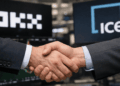En primer plano, un apretón de manos. En el fondo, los logos de OKX e ICE.