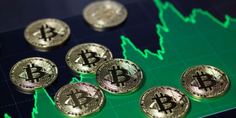 Monedas físicas de bitcoin sobre un gráfico de precios alcista.