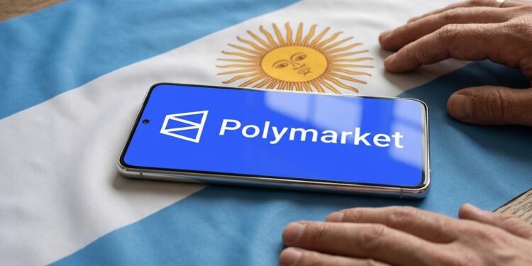 Teléfono inteligente que muestra el logo de Polymarket sobre una bandera de Argentina y con dos manos al lado.