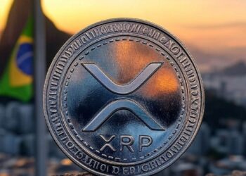 Moneda física de XRP de Ripple sobre fondo del atardecer en Río de Janeiro y bandera de Brasil.