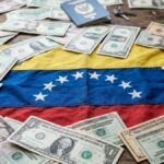 Bandera de Venezuela sobre una mesa con dรณlares alrededor.