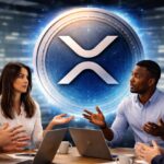 Personas debaten en una oficina que tiene una moneda física de XRP en su pared.