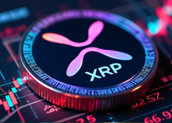 Una moneda física de XRP sobre gráficos de precio.