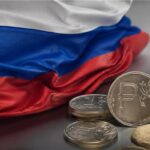 Bandera de Rusia al lado de unas monedas, del rublo.