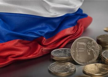 Bandera de Rusia al lado de unas monedas, del rublo.