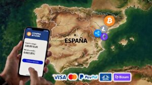 Teléfono celular y criptomonedas sobre el mapa de España al fondo.