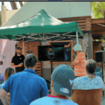 Un grupo de personas están de espaldas observando la exposición de un ponente en el evento Bitcoin Freedom de Costa Rica.