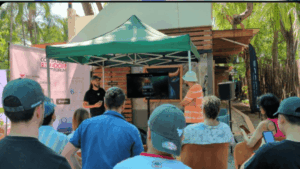 Un grupo de personas están de espaldas observando la exposición de un ponente en el evento Bitcoin Freedom de Costa Rica.