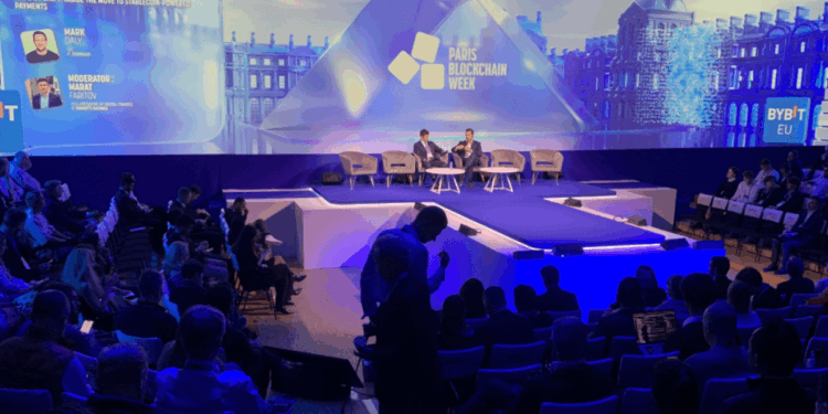 Bitcoiners y entusiastas de las criptomonedas frente al escenario de la París Blockchain Week 2026.