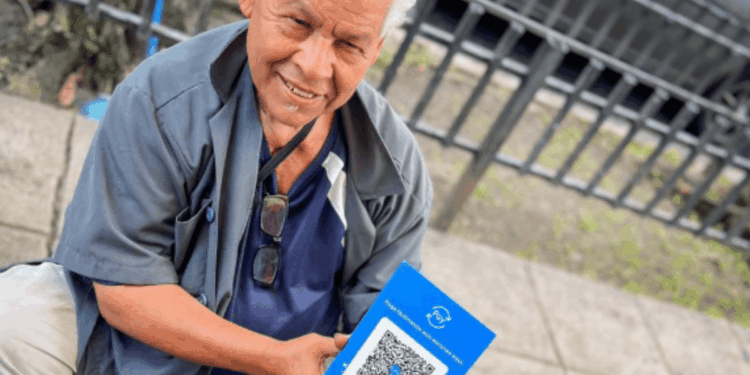 Una persona de El Salvador sostiene en sus manos el método de pago Pay.