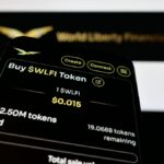 Teléfono con la página web de WLFI junto a su logo.