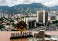 Logo de Binance, monedas de USDT, bancos y Caracas de fondo.