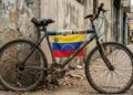 Una bicicleta en mal estado que tiene el logo de USDT, dólares y la bandera de Venezuela.