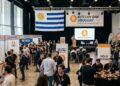 Personas reunidas en un evento de Bitcoin con la bandera de Uruguay.