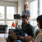 Tres personas de diferentes edades revisan gráficos de precio en sus pantallas.
