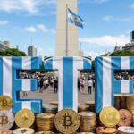 Palabra ETF vestida con un jersey de la selección de Argentina, en el Obelisco. Con monedas físicas de bitcoin y otras criptomonedas apiladas alrededor.