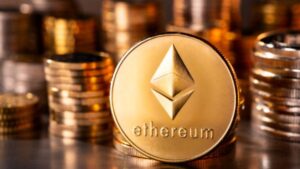 Monedas físicas de ether en un escritorio con más monedas apiladas en el fondo.