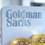 Logotipo de Goldman Sachs acompañado de varias monedas doradas físicas de bitcoin.