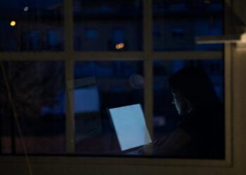 Mujer a través de una ventana trabajando en una computadora
