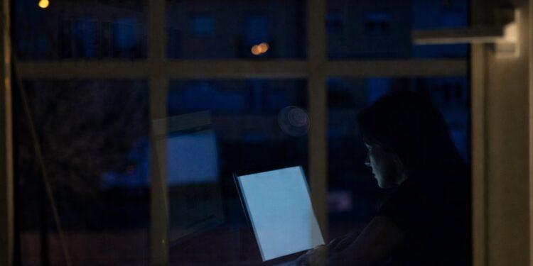 Mujer a través de una ventana trabajando en una computadora