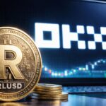 Moneda RLUSD frente a pantalla con logo de OKX y gráfico de criptomonedas en entorno tecnológico.