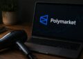 Un secador de pelo junto a una notebook que muestra el logo de Polymarket