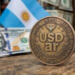 Moneda que tiene grabada la palabra USDar y en los bordes que diga "RIPIO". Con dólares y la bandera de Argentina en el fondo.