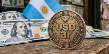Moneda que tiene grabada la palabra USDar y en los bordes que diga "RIPIO". Con dólares y la bandera de Argentina en el fondo.