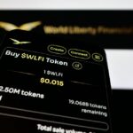 Teléfono con la página web de WLFI junto a su logo.