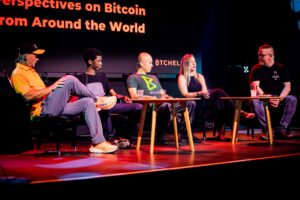 Panel de discusión sobre Bitcoin con cinco conferencistas en el escenario de "BTCHEL 2026".