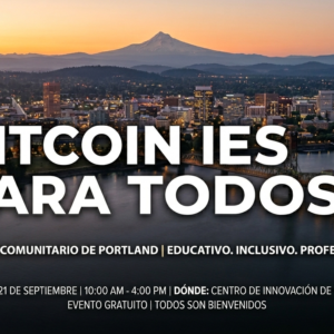 A vista aérea de la ciudad de Portland con el Monte Hood y un texto superpuesto en color blanco y naranja: "BITCOIN IS FOR EVERYONE"