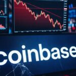 Gráficos bursátiles rojos en fuerte descenso en una sala de trading con el logo de Coinbase en primer plano.