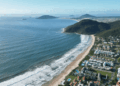 Vista panorámica aérea de Florianópolis, Brasil, mostrando el perfil costero de la ciudad bajo una luz cálida al atardecer.