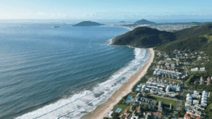 Vista panorámica aérea de Florianópolis, Brasil, mostrando el perfil costero de la ciudad bajo una luz cálida al atardecer.