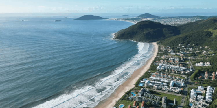 Vista panorámica aérea de Florianópolis, Brasil, mostrando el perfil costero de la ciudad bajo una luz cálida al atardecer.