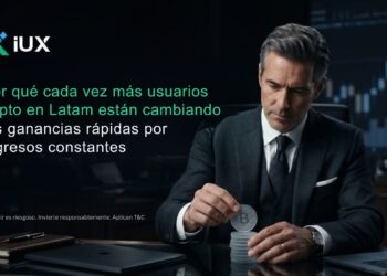Banner de IUX, traders de Latam cambian su mentalidad, a la derecha un hombre de traje en su oficina, apilando monedas de Bitcoin