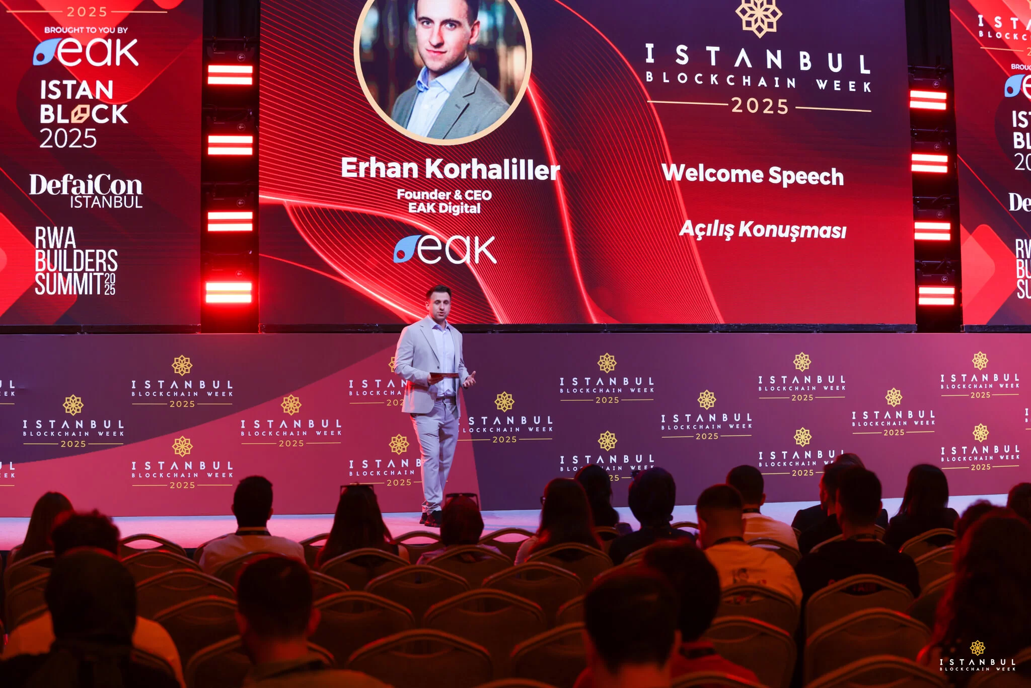 Conferencia de Istanbul Blockchain Week 2025 con Erhan Korhaliller dando el discurso de apertura ante el público.