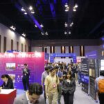 Público asistente en un auditorio oscuro presenciando el escenario iluminado con luces azules del evento Blockchain Life en Dubái.