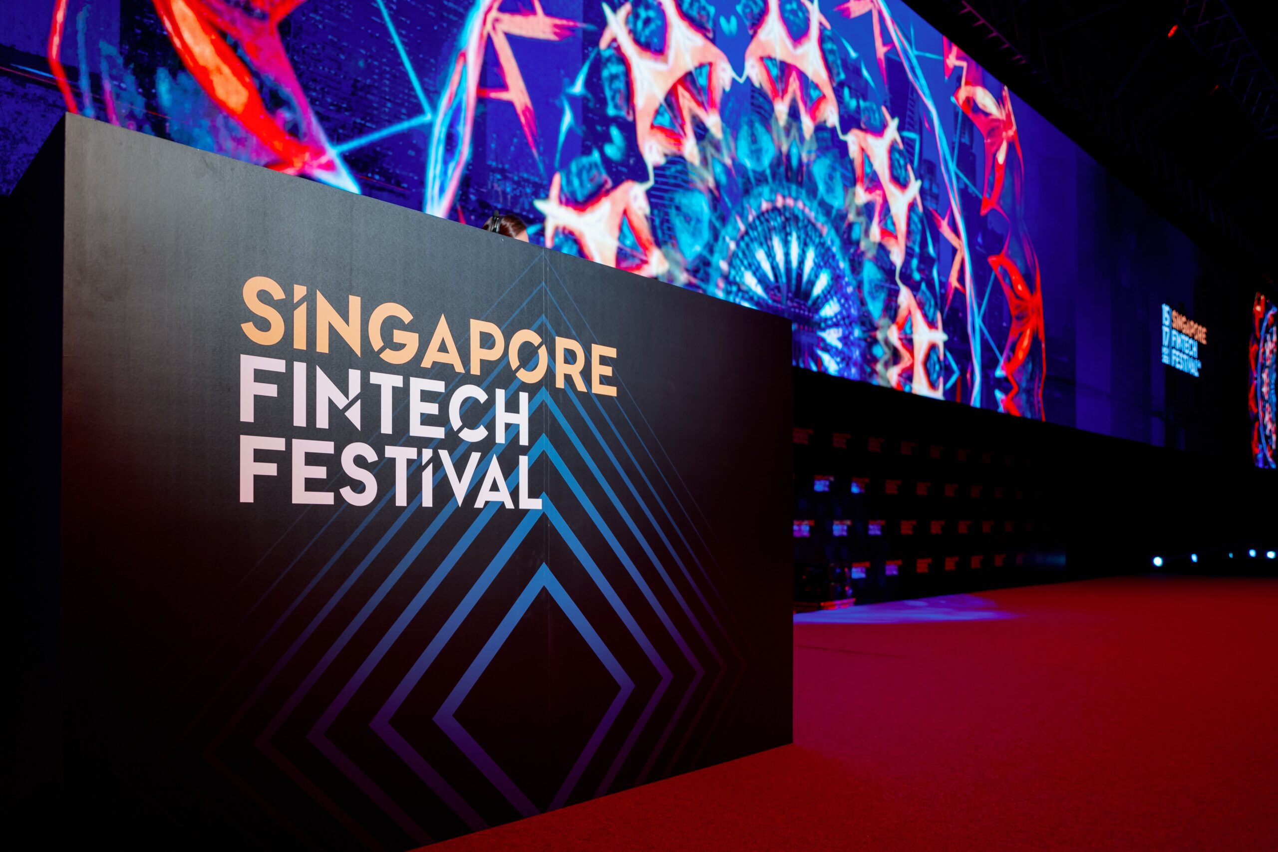 Escenografía del Singapore FinTech Festival 2026 con pantallas brillantes en un entorno oscuro.