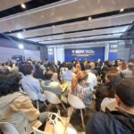 Grupo de personas en un salón escuchando la intervención del cofundador de Coinbase