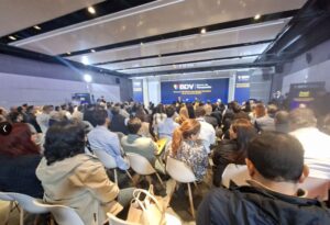 Grupo de personas en un salón escuchando la intervención del cofundador de Coinbase