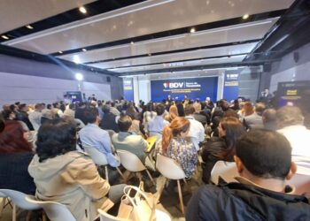 Grupo de personas en un salón escuchando la intervención del cofundador de Coinbase