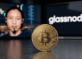 En primer plano: moneda física de bitcoin. En el fondo: imágenes de Willy Woo y del logo de Glassnode.