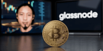 En primer plano: moneda física de bitcoin. En el fondo: imágenes de Willy Woo y del logo de Glassnode.