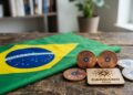 Bandera de Brasil junto al logo y monedas de Cardano sobre un escritorio.