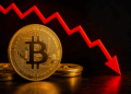 Moneda de bitcoin con una flecha roja cayendo
